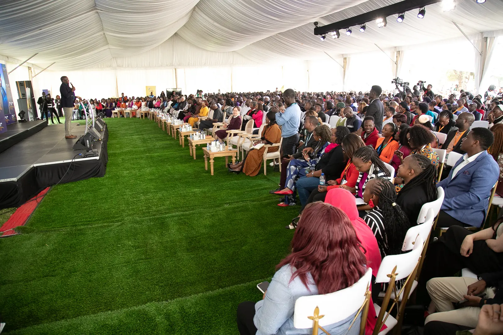 The Business Forum tent, packed with delegates under stage lighting