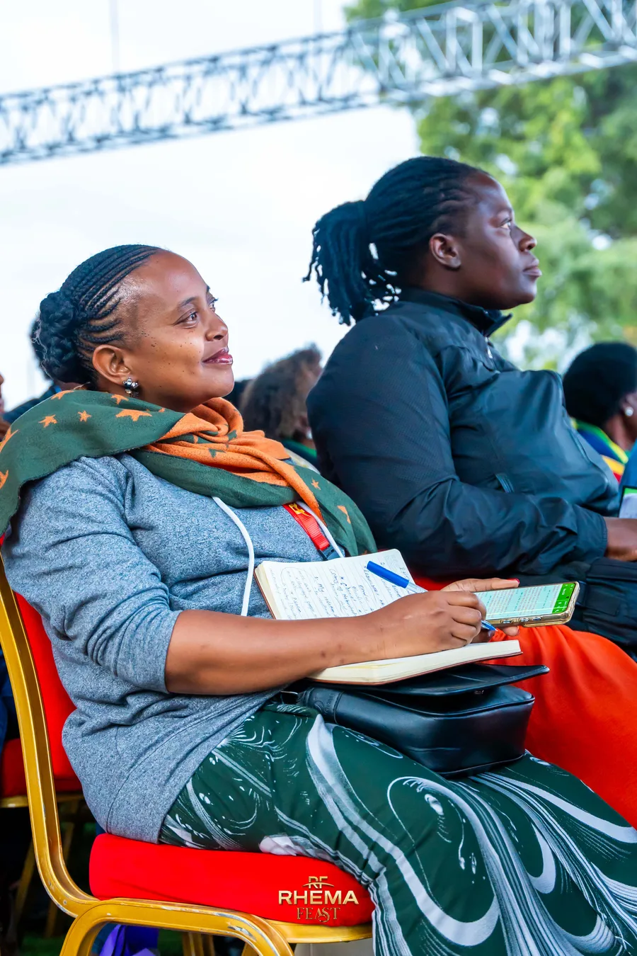 A delegate with an open notebook resting on her lap