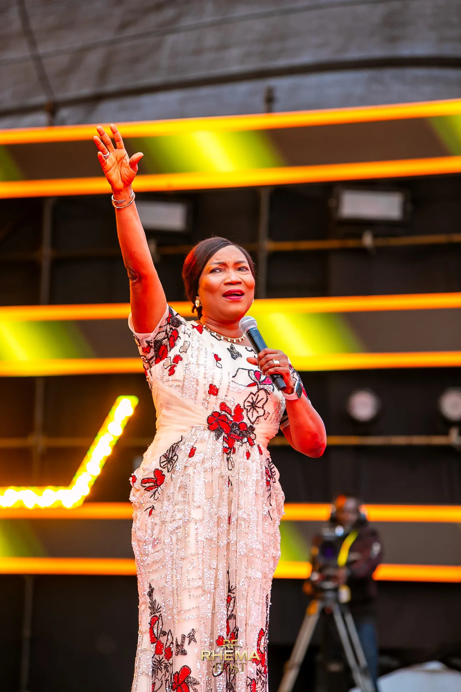 Bishop Funke Felix-Adejumo with one arm raised as she preaches