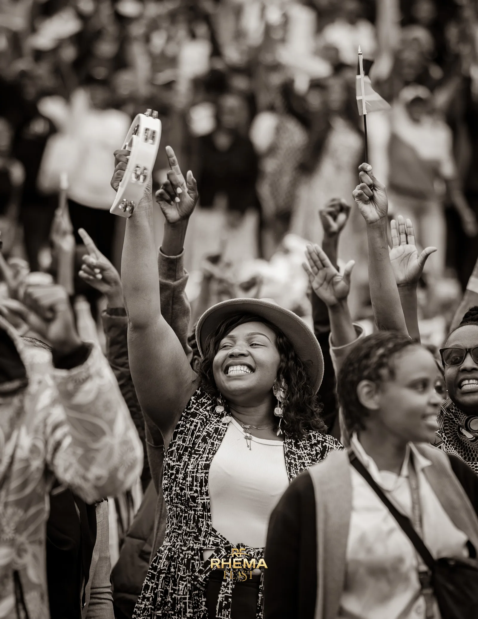 Hands and phones raised in a delighted crowd, a woman laughing at the centre
