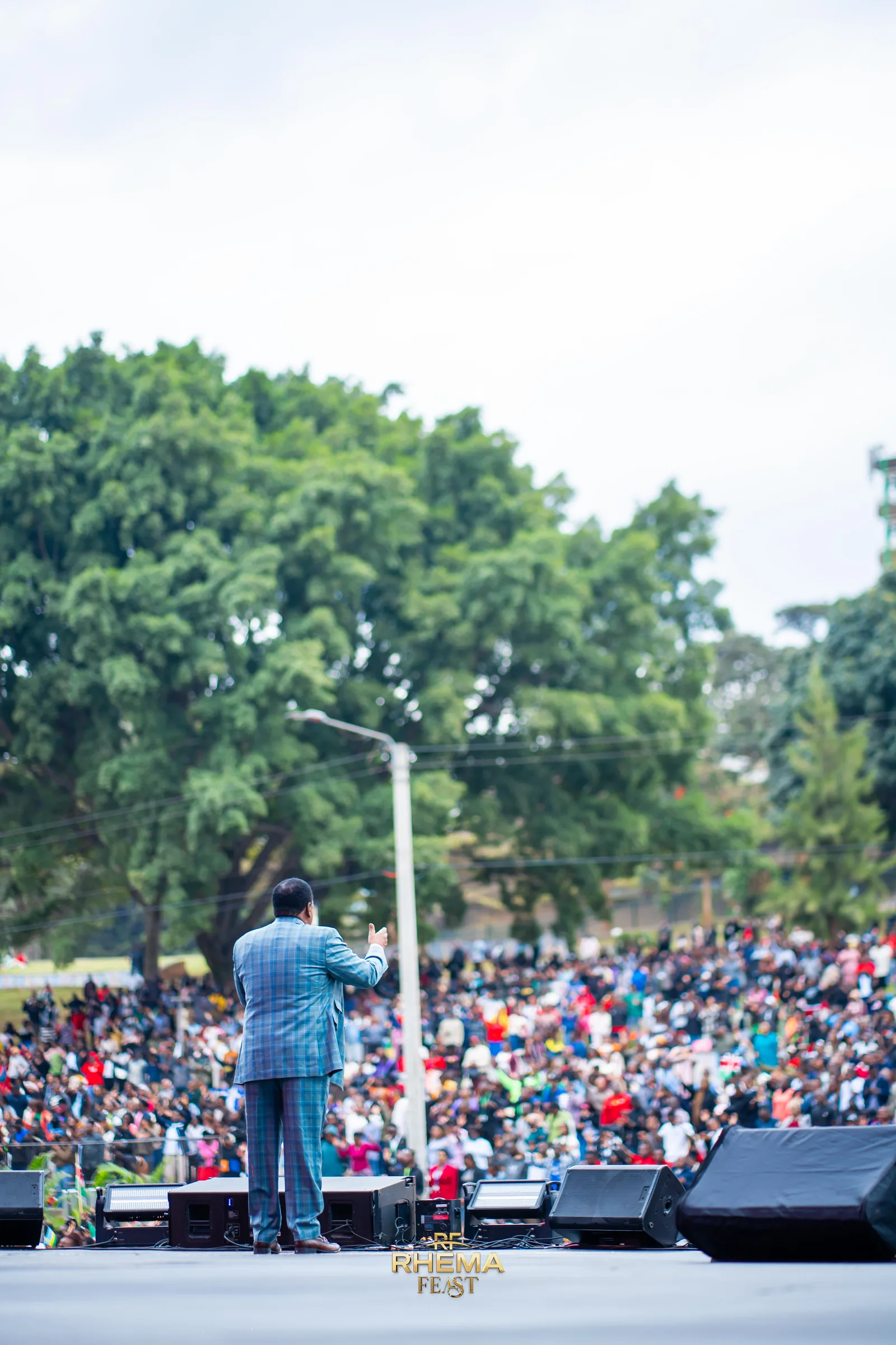 Bishop J.B. Masinde on the stage edge, preaching to a field of thousands