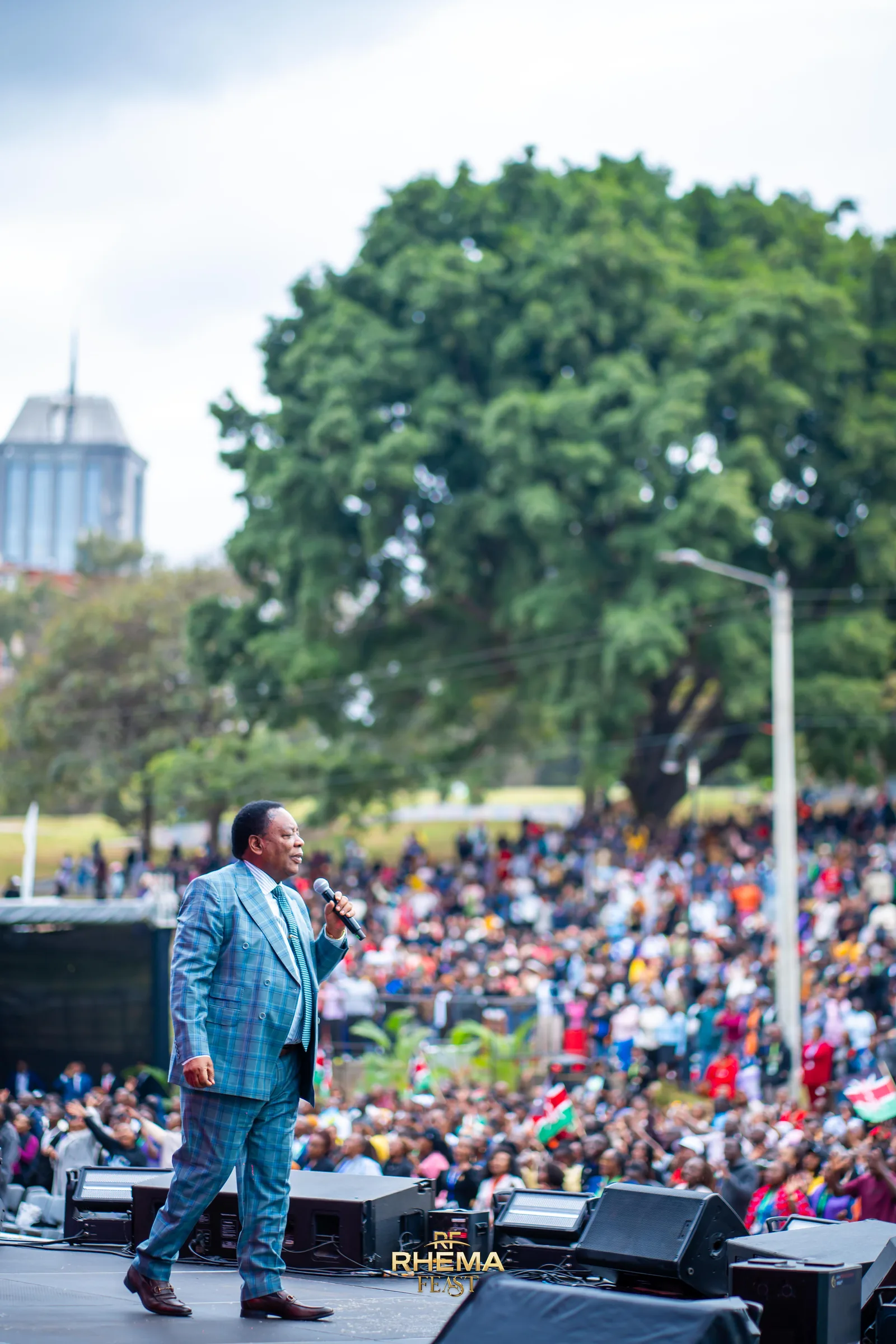 Bishop J.B. Masinde preaching in daylight, the crowd filling the frame behind him