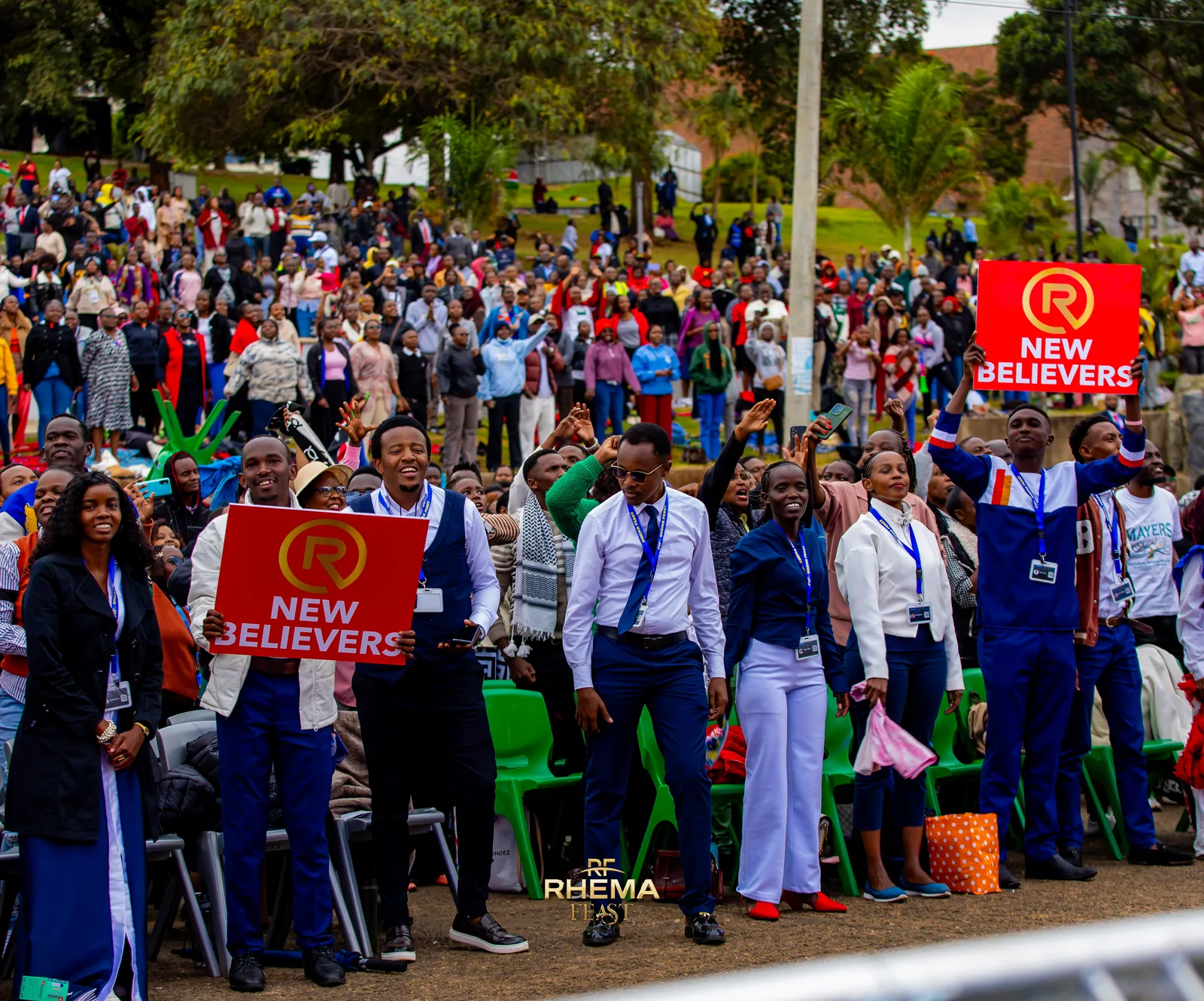 New believers standing together across the park, placards above them