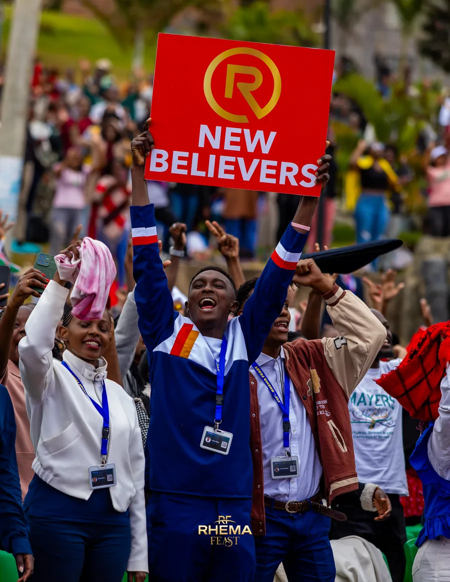 A new believers placard held up in a crowd of raised hands