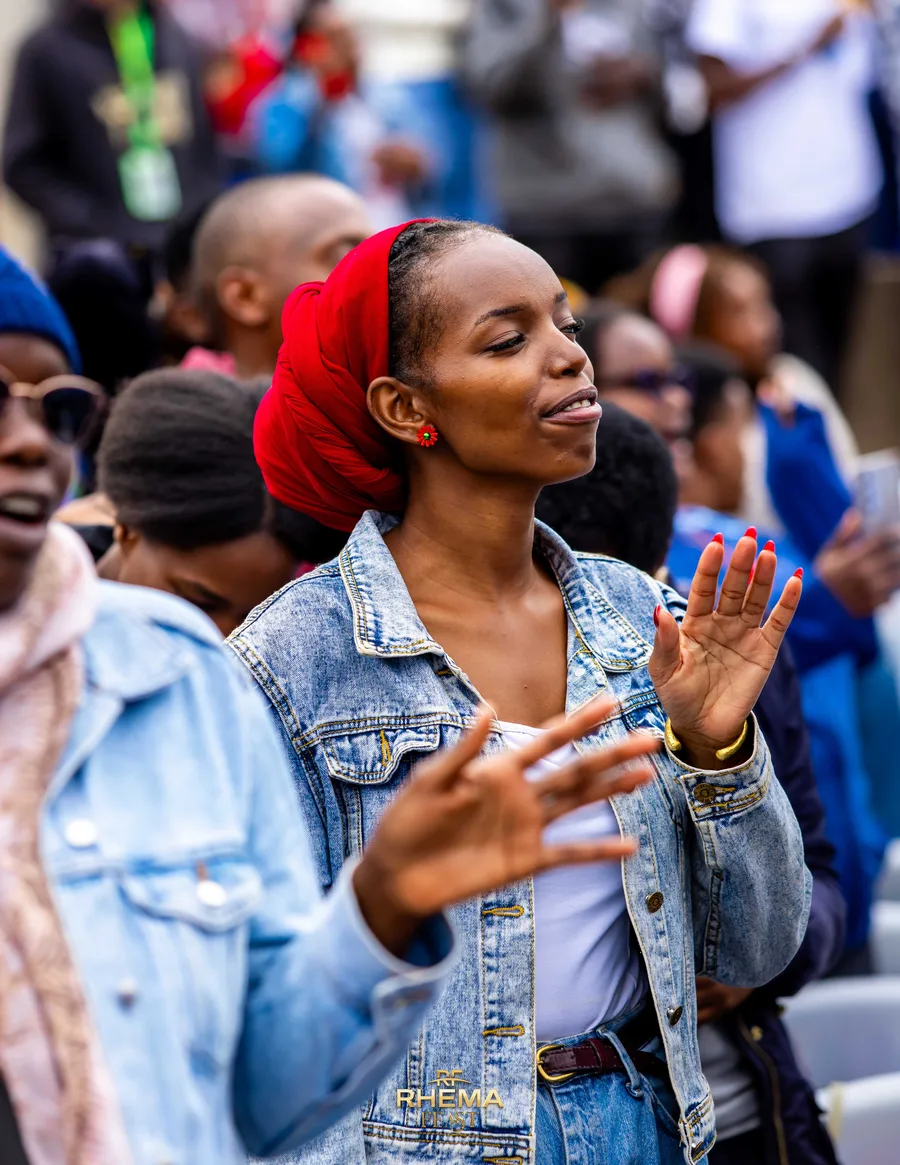 A young woman in the crowd worshipping with her eyes closed