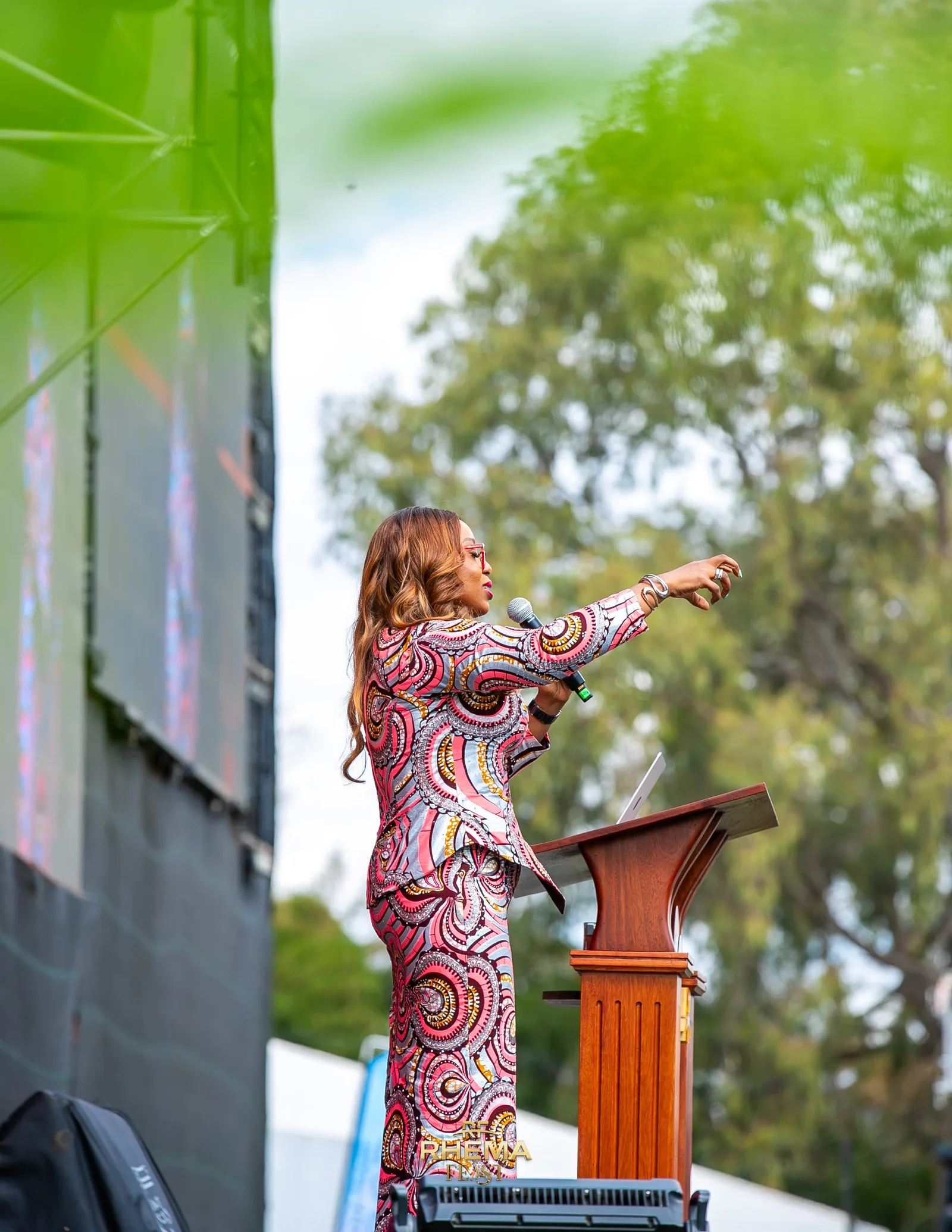 Apostle Isi Igenegba at the podium, the crowd stretching behind her