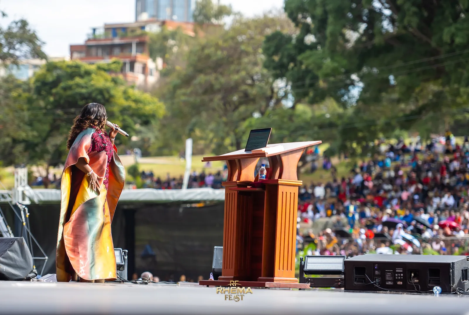 Lady Bishop Kathy Kiuna at the podium, the field stretching behind her