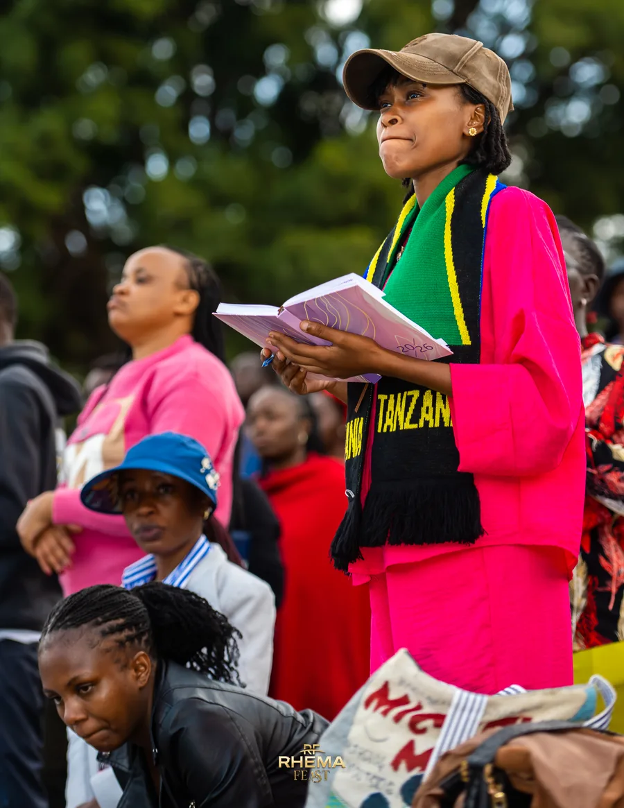 A delegate in a Tanzania sash taking notes during the sermon