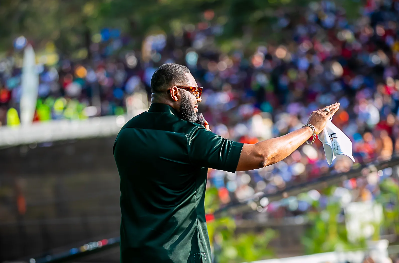 Felix Okoh with one arm outstretched toward the crowd