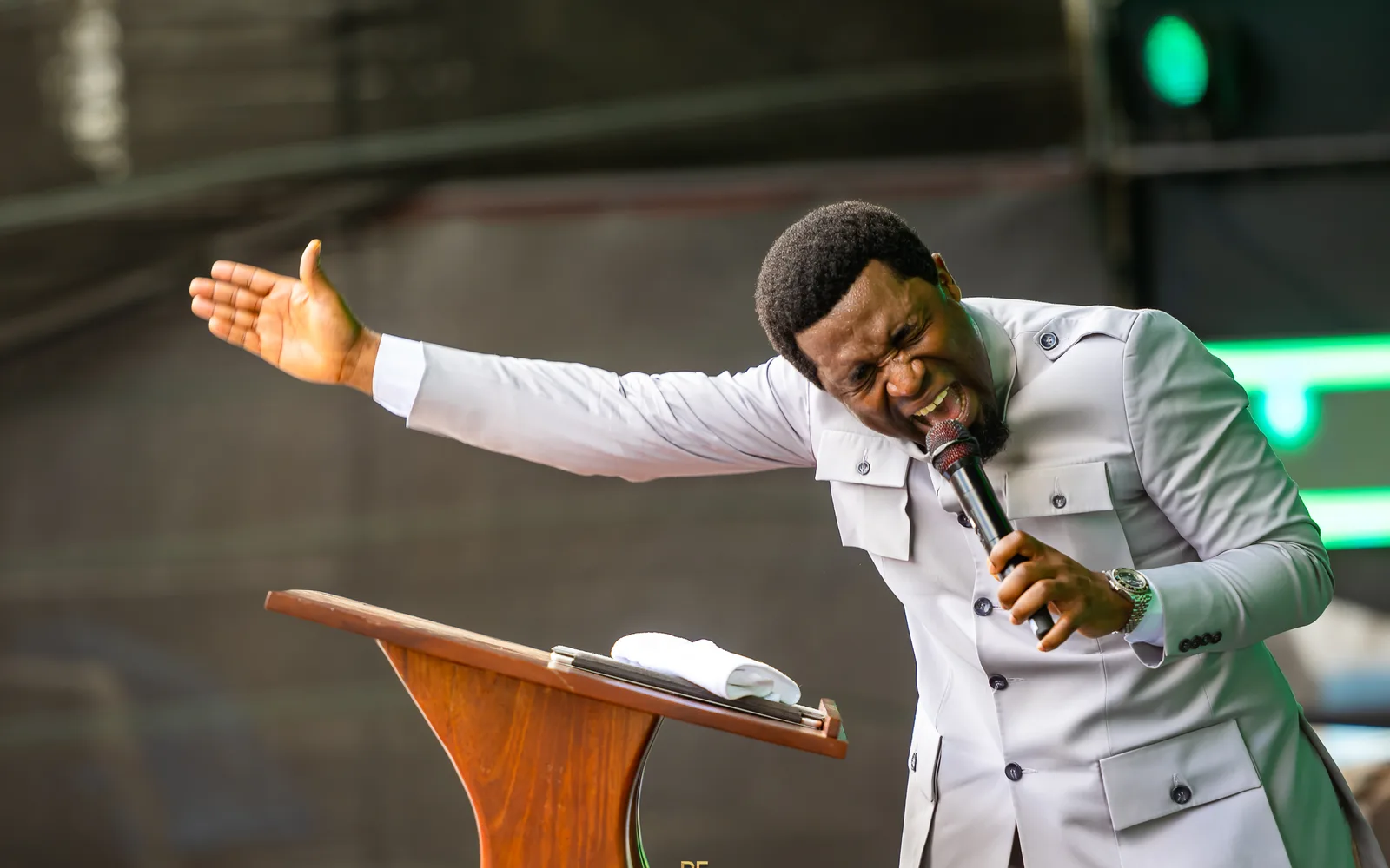 Apostle Michael Orokpo preaching, arm outstretched