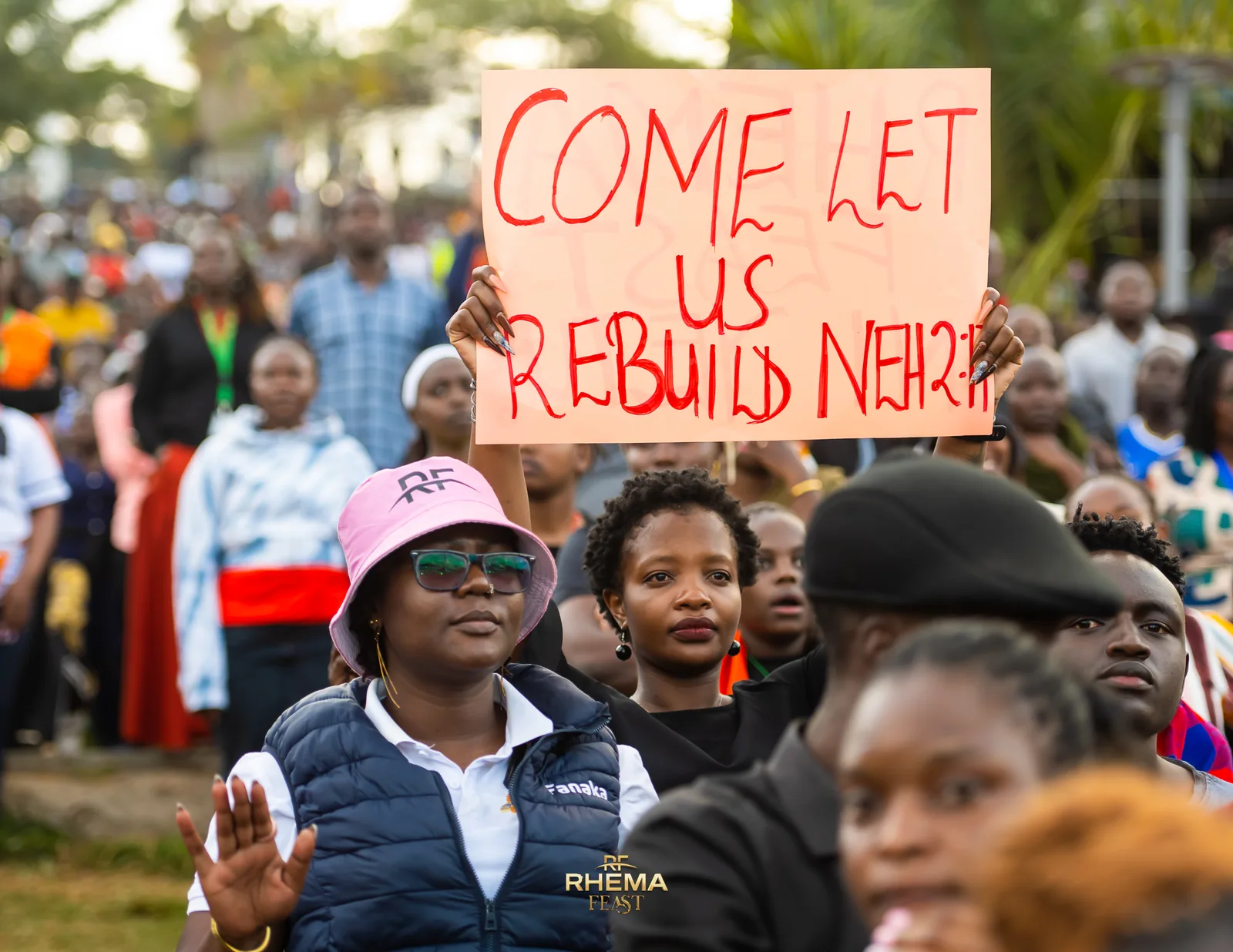 Delegates holding hand-lettered Come Let Us Rebuild placards above the crowd