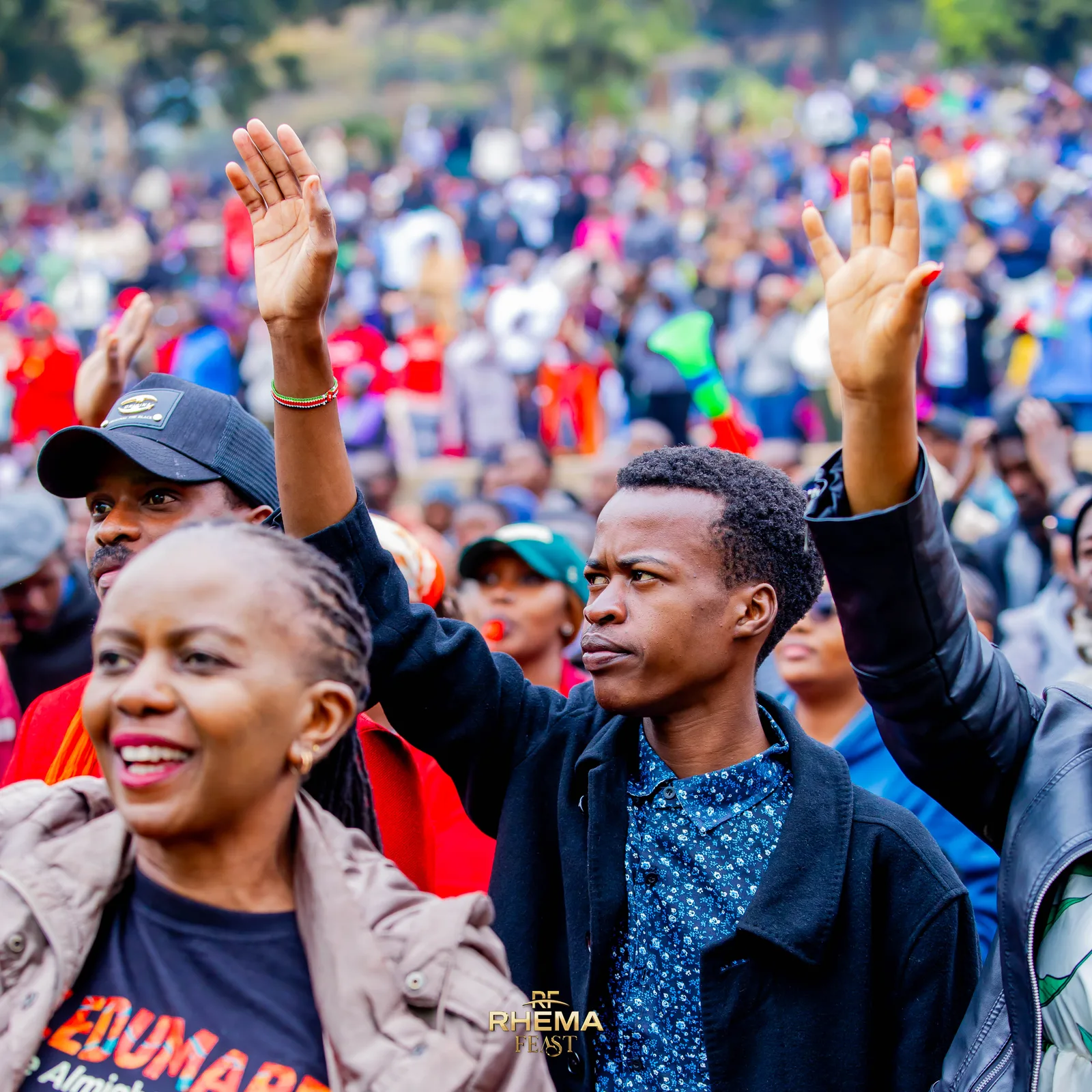 Hands raised across the crowd in the afternoon light