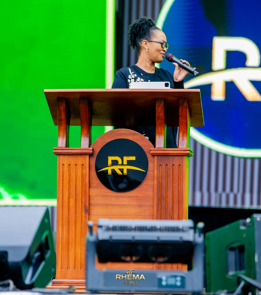 Apostle Mignonne Kabera at the podium, the RF mark behind her