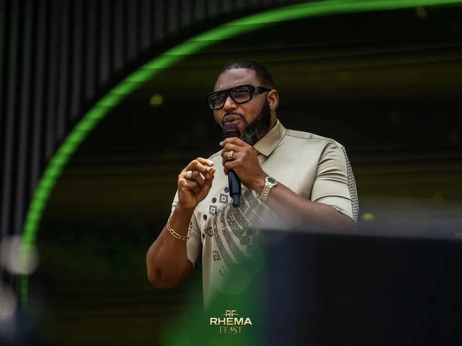 Apostle Felix Okoh mid-sentence, hands together