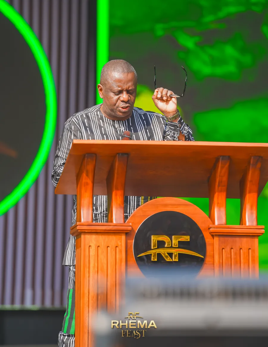 Apostle Poju Oyemade at the lectern, glasses in hand