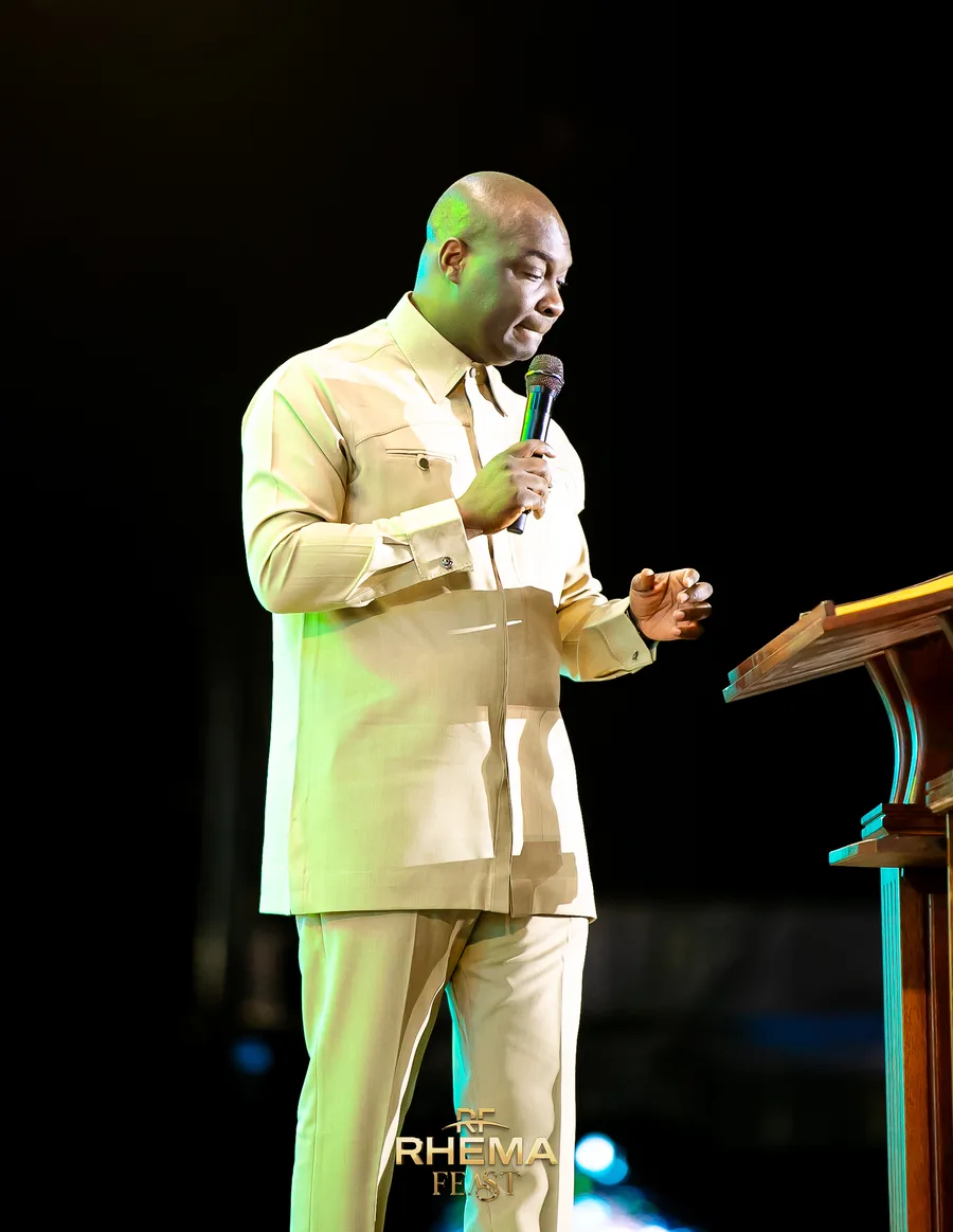 Apostle Joshua Selman with his head bowed at the podium